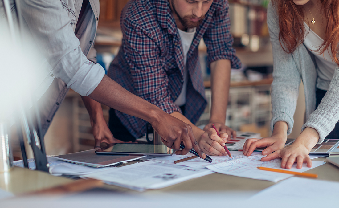 Image of three people working together at a table